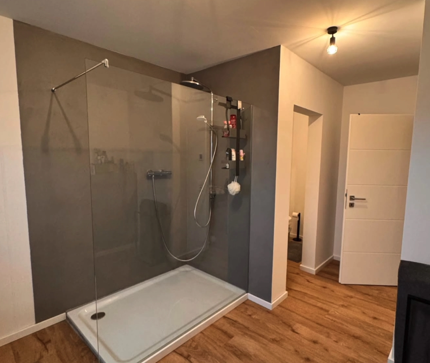 Fugenloses Bad und begehbare Dusche - Gestaltung eines modernen Badezimmers mit fugenlosen Wänden im Duschbereich und passenden Bodenbelägen.