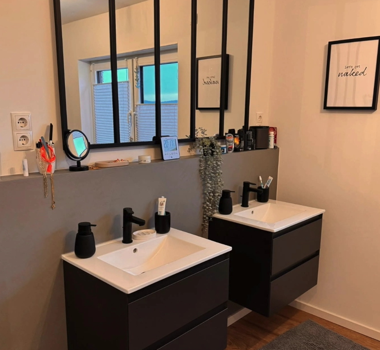 Badezimmer Wandgestaltung - Moderne Akzentwand mit grauem Farbanstrich und indirekter Beleuchtung im Badezimmer mit zwei Waschtischen.