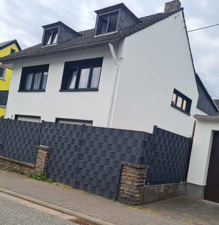 Fassadenrenovierung Einfamilienhaus - Fassadenanstrich in Weiß mit Akzenten, inklusive Neuanstrich von Fenstern und Dachgauben.