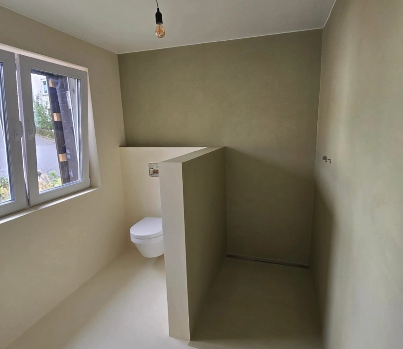 Badezimmer Microzement fugenlos - Fugenloses Badezimmer mit Spachteltechnik Wänden und passendem Boden in Grüntönen. Modernes und pflegeleichtes Oberflächenfinish.